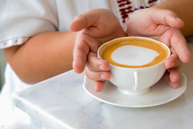 Une femme tenant une tasse de café