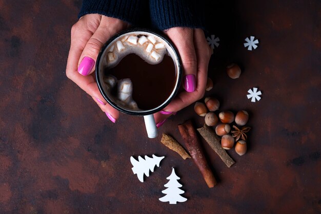 Femme tenant une tasse de chocolat chaud.