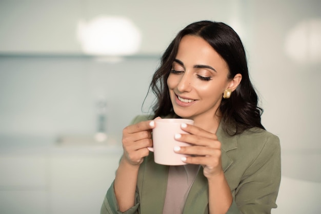 Photo femme tenant une tasse à l'intérieur à la maison dans un appartement