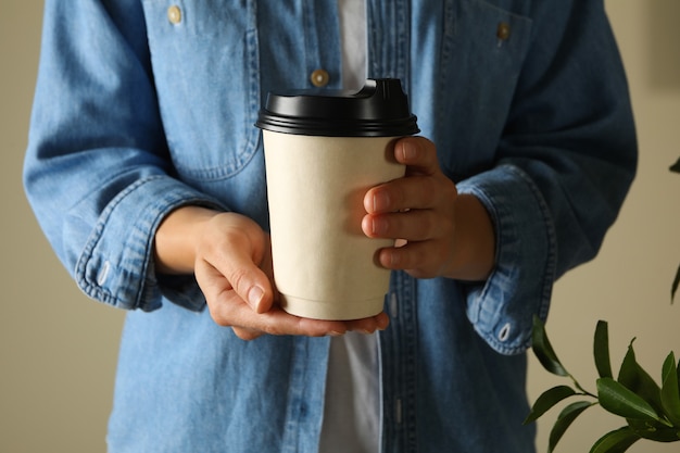 Femme tenant une tasse de papier vierge