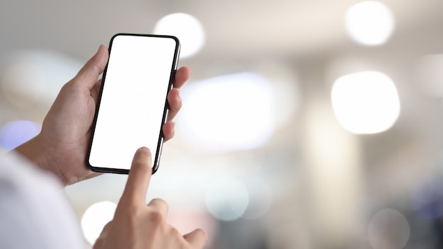 Photo femme tenant et touchant un smartphone à écran blanc