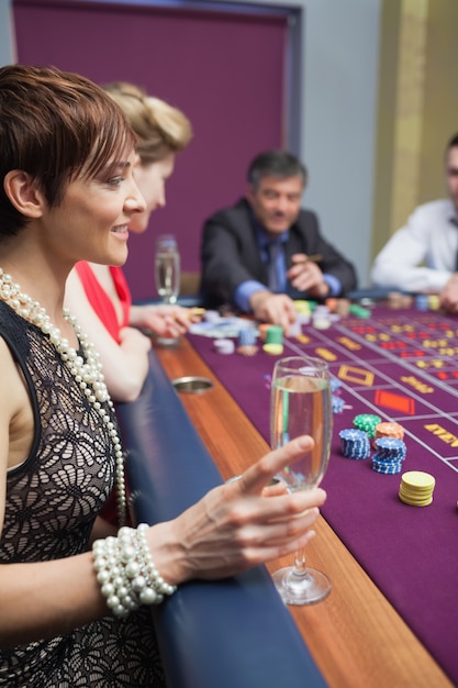 Photo femme tenant un verre de champagne à la roulette