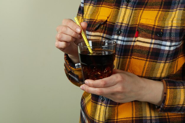 Femme tenant un verre de cola avec de la glace