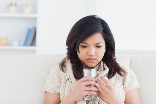 Femme tenant un verre d&#39;eau tout en ayant froid