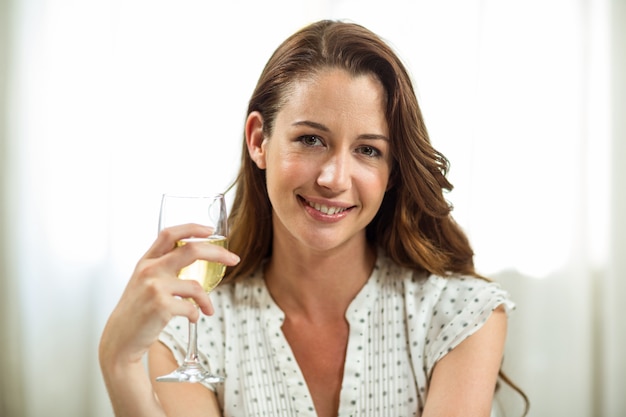 Femme tenant un verre de vin à la maison