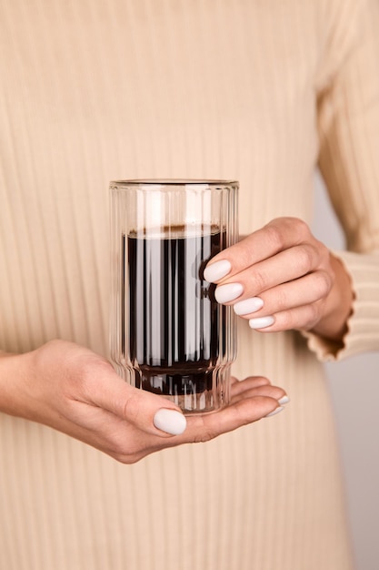 Une femme tenant des verres de café dans ses mains.