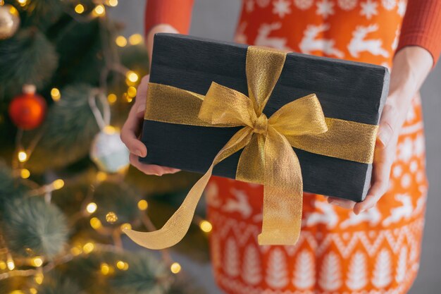 Femme tend la main avec une boîte-cadeau et donne un cadeau