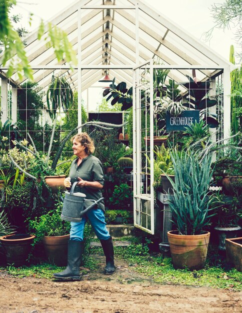 Femme tendant des plantes dans une serre