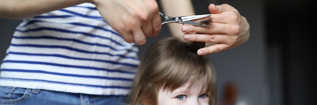 Femme tenir des ciseaux et mèche de cheveux pour enfant