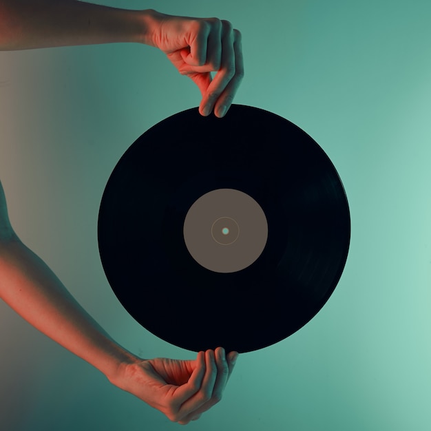 Femme tenir un disque vinyle rétro dans les mains photo tonique