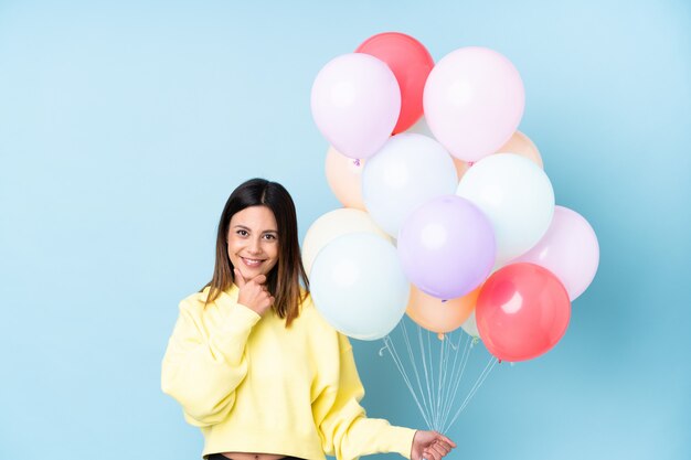 Femme, tenue, ballons, fête, isolé, bleu, mur, rire