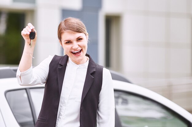 Femme, tenue, clés, voiture neuve, voiture, sourire, caméra