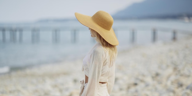 Femme en tenue de plage élégante à l'extérieur sur fond de mer pendant les vacances d'été