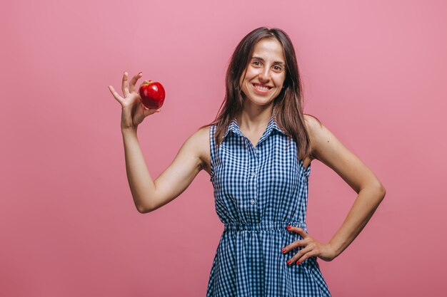 femme, tenue, pomme rouge, sur, mur rose