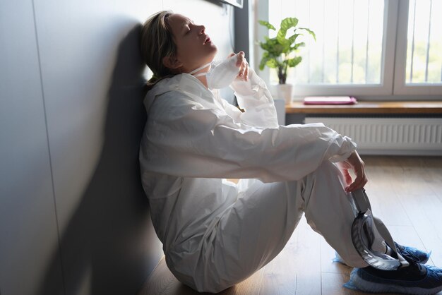 Une femme en tenue de protection respire sans masque