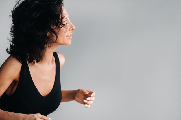 Une femme en tenue de sport noire est engagée dans une méditation kali dynamique dans la salle de yoga