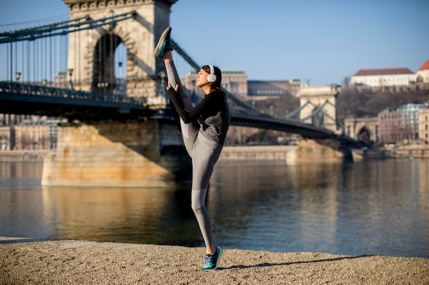 Femme en tenue de sport s&#39;étendant sur la promenade du Danube à Budapest