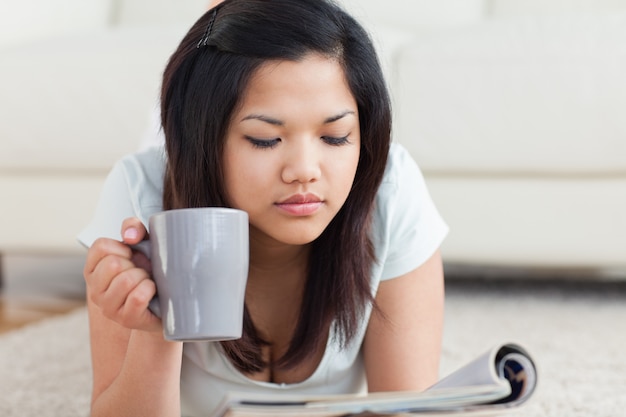 Femme, tenue, tasse, lecture, magazine