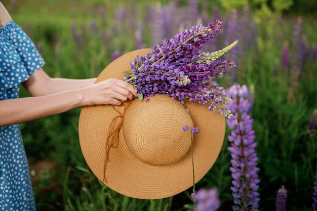 Une femme sur le terrain recueille un bouquet de lupins