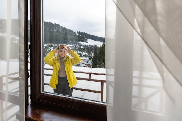 Femme sur une terrasse admirant dans les montagnes enneigées