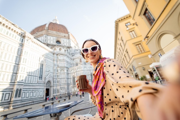 Femme à la terrasse d'un café près de la cathédrale du Duomo à florence voyageant en italie