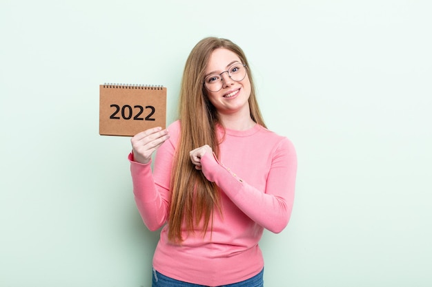 Femme à tête rouge se sentant heureuse et faisant face à un défi ou célébrant le concept de l'agenda 2022