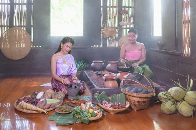 Femme thaïlandaise cuisine en robe thaï rétro