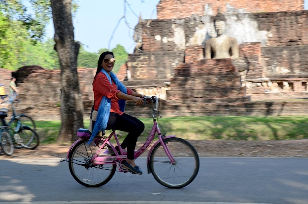 Femme thaïlandaise faisant du vélo sur la route pour visiter la ville historique de Sukhothai et les villes historiques associées de Sukhothai en Thaïlande