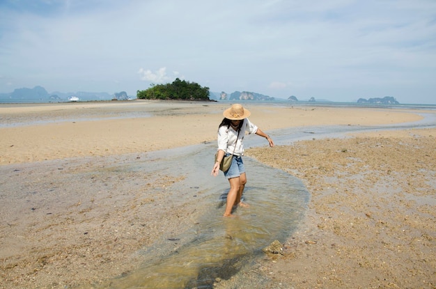 Femme thaïlandaise jouant et portrait pour prendre des photos sur la plage ou la mer tombolo aller sur une petite île de l'océan andaman tandis que le niveau de l'eau de mer a diminué à Koh Yao Noi à Phang Nga en Thaïlande