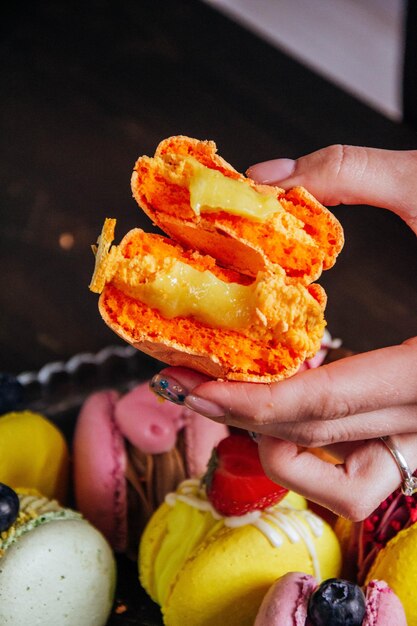 Une femme tient un bagel avec un dessert fruité en arrière-plan