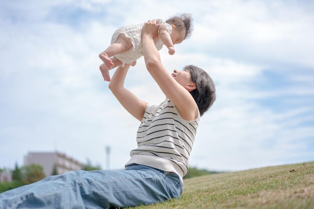 Une femme tient un bébé dans les airs.