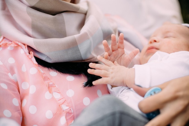 La femme tient le bébé endormi fermement la vie des bras