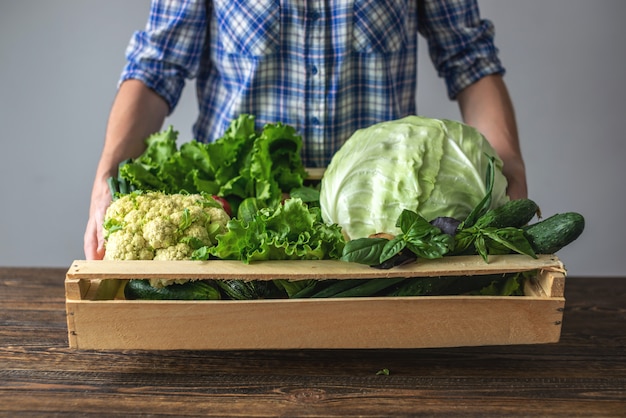 Femme tient une boîte de légumes frais et sains