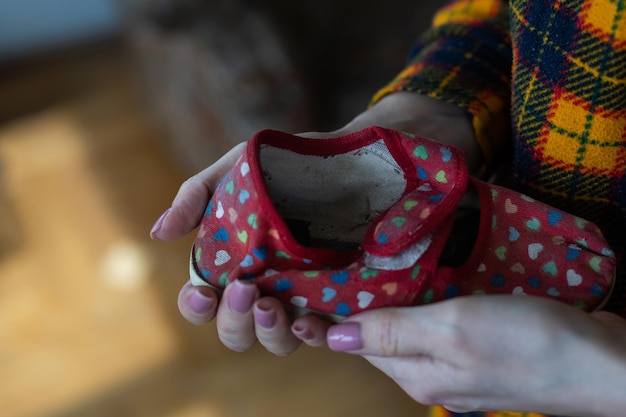 Une femme tient une chaussure d'enfant. Guerre en Ukraine.