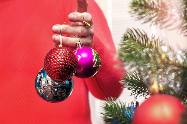 Une femme tient des décorations d'arbre de Noël dans sa main