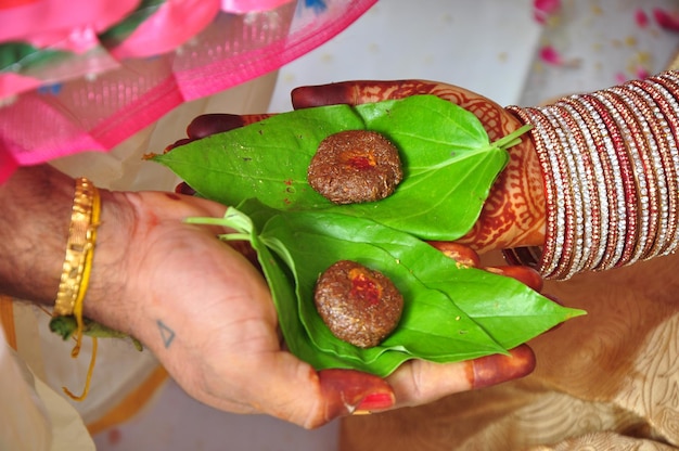 Une femme tient une feuille verte avec deux boulettes de viande dessus.