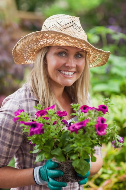 Une femme tient des fleurs dans le jardin