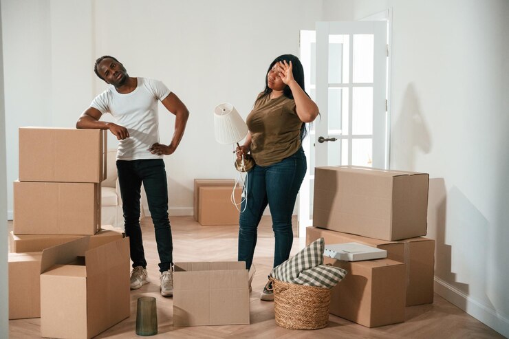 Photo une femme tient une lampe. un couple afro-américain emménage dans une nouvelle maison.