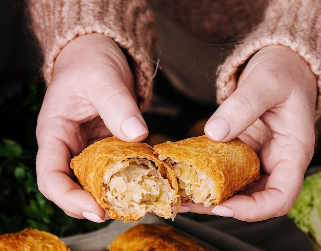 une femme tient une pâtisserie roumaine avec du chou