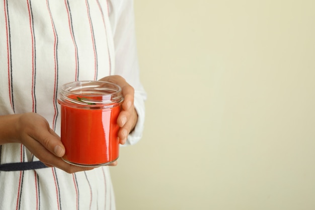 La femme tient le pot de la soupe savoureuse de gaspacho