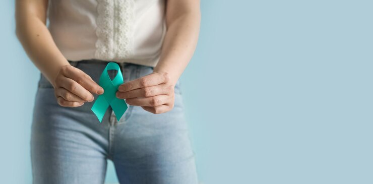 La femme tient le ruban Teal symbolique pour le cancer du col de l'utérus le cancer de l'ovaire le cancer gynécologique et le SOPK