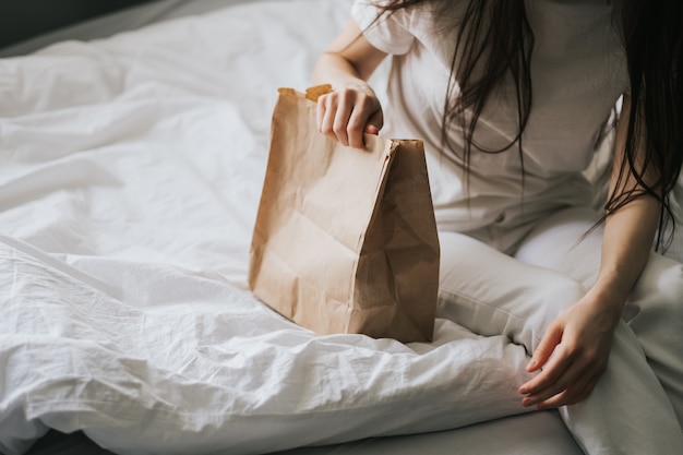 Femme tient un sac écologique en papier dans les mains