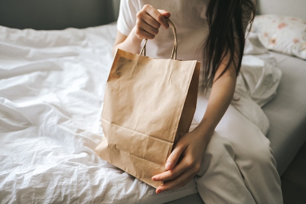 Femme tient un sac écologique en papier dans les mains