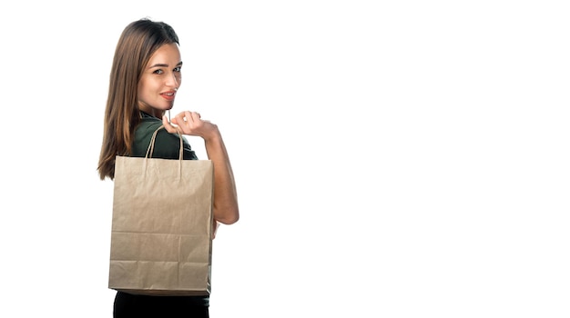 Femme tient un sac d'épicerie sur fond blanc. Jeune fille tient un sac à provisions marron clair derrière le dos. Fond isolé. Fermer.