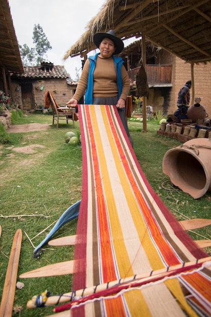 Photo une femme tient une serviette de plage rayée dans une cour.