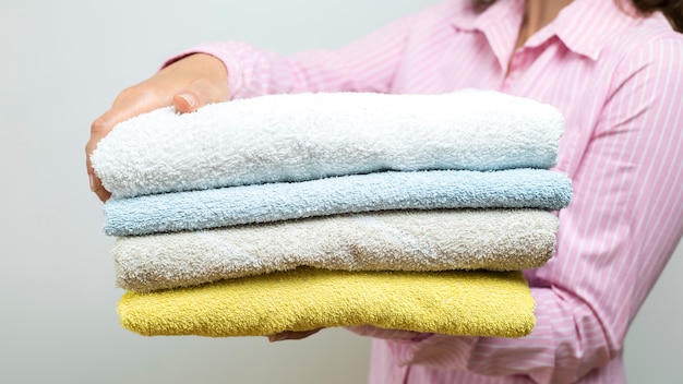 Une femme tient des serviettes propres pliées.