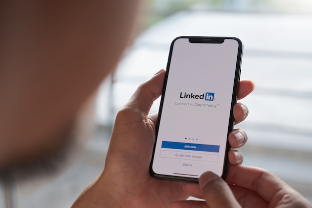 Photo une femme tient un smartphone avec une application linkedin sur l'écran