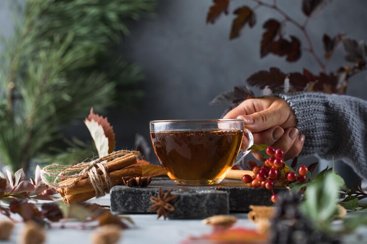Photo une femme tient une tasse de délicieux thé fraîchement infusé dans sa main le concept du temps d'automne