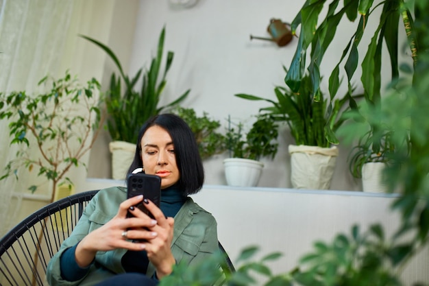 Une femme tient un téléphone portable et surfe sur un message de type internet