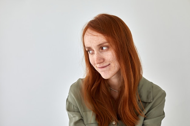 Femme timide avec une peau de taches de rousseur et des cheveux roux